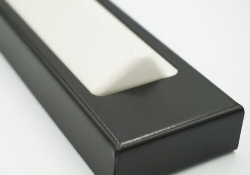 Svartlackad armbågskontakt med vit knapp